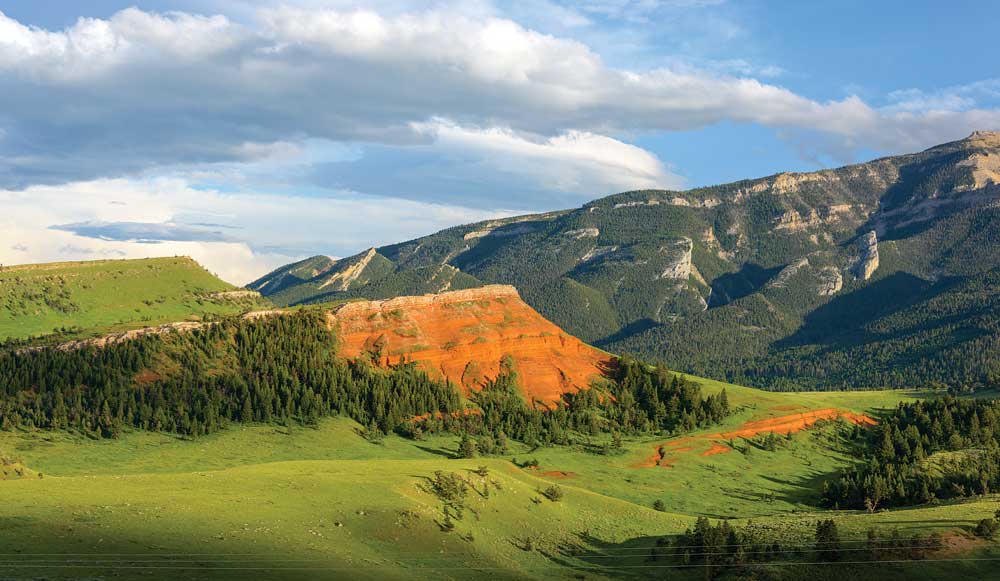 Chief Joseph Byway, Wyoming — A red volcanic hill under the Absaroka wall