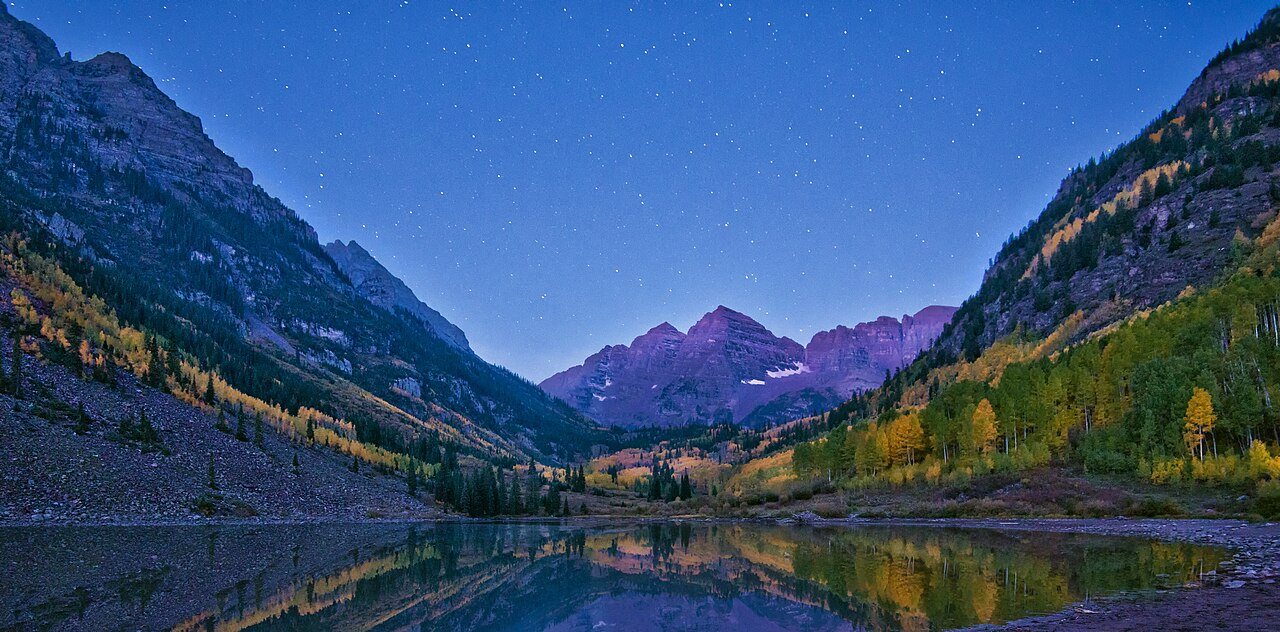 Autumn aspens flare gold beneath twin maroon summits
