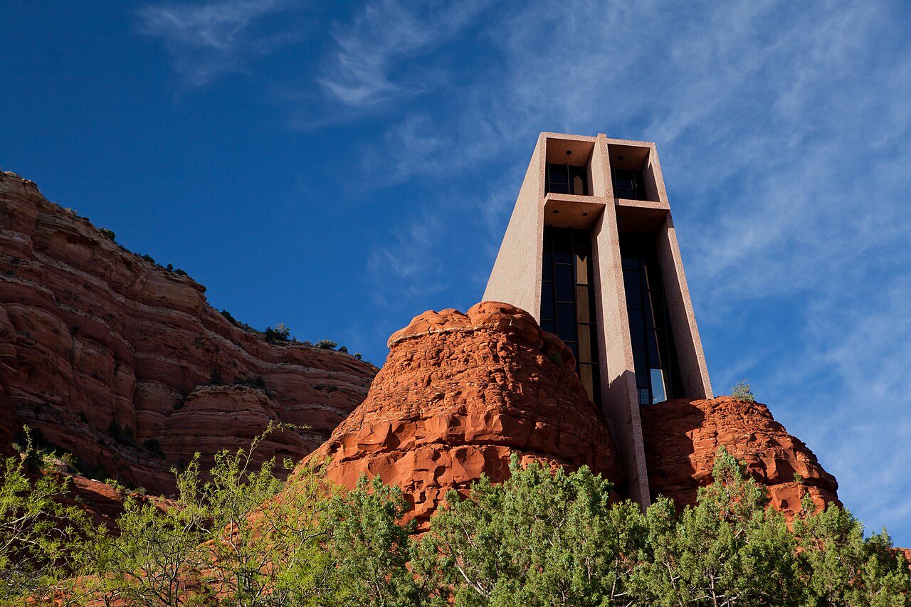 Red butte rising from a juniper-dotted basin
